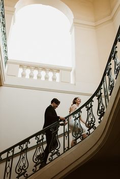 a bride and groom walking down the stairs