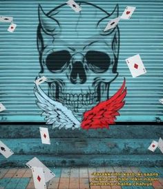 a painting on the side of a garage door with playing cards falling from its mouth