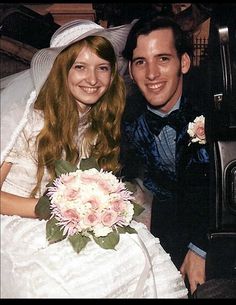 a bride and groom sitting in the back of a car with flowers on their lap