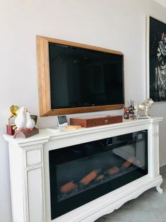 a television mounted on top of a white fireplace