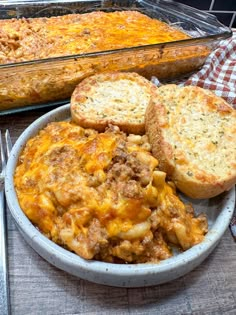 a bowl filled with food next to a casserole covered in cheese and bread