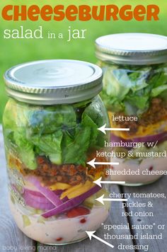 two mason jars filled with salads on top of a wooden table in the grass