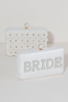 Bring your bridal celebrations wherever you go with Shiraleah's "Bride" Pearl Minaudiere. This classic white purse features the word "Bride" embroidered in chic faux pearls with a faux pearl top closure. You can carry it like a clutch or use the detachable cross-body chain for some extra versatility in your style. Pair with other items from Shiraleah's Hitched collection to complete your look! Features a detachable cross-body chain and a magnetic frame closure Shiraleah is a trend-driven lifesty White Pearl Clutch Gift, White Clutch With Pearl Handle As Gift, White Rectangular Clutch With Pearl Embroidery, White Pearl Embroidered Clutch For Formal Occasions, White Pearl Embroidery Clutch For Formal Occasions, Formal White Clutch With Pearl Embroidery, White Clutch With Pearl Embroidery As Gift, White Pearl Wedding Clutch, White Bridal Accessories With Pearl Embroidery For Formal