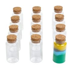 six glass bottles with cork lids are lined up next to each other