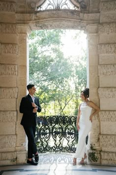 a man and woman standing in front of an open window