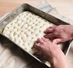 a person is placing dough into a pan