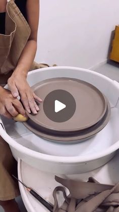 a woman is working on a pottery bowl