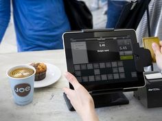 a person sitting at a table with an ipad and cup of coffee in front of them