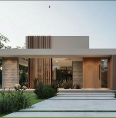 a modern house with grass and trees in the front yard