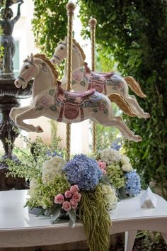 a white table topped with flowers and a carousel