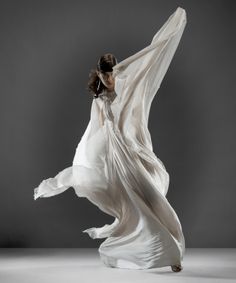 a woman in a white dress is dancing