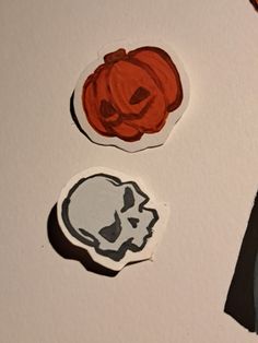 three halloween stickers on top of a piece of paper with scissors next to them