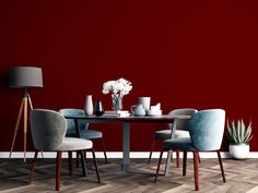 a dining room with red walls and wooden flooring