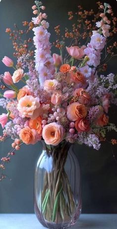 a vase filled with lots of pink and orange flowers