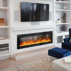 a living room with a large television mounted on the wall and a fire place in front of it