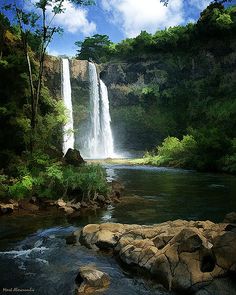 a large waterfall in the middle of a forest