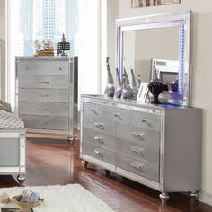 a bedroom scene complete with a bed, dresser and mirror on the sideboard in silver