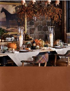 the table is set with candles, pumpkins and other decorations