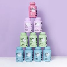 six jars of hair care products stacked on top of each other in front of a purple background