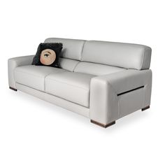 a white leather couch with a pillow on it