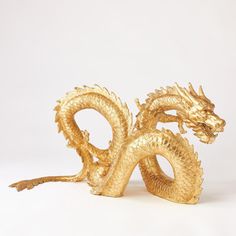 a golden dragon statue sitting on top of a white table