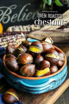 a bowl filled with chestnuts on top of a wooden table