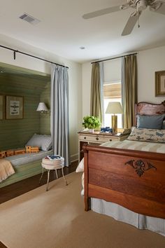 a bed room with a neatly made bed next to a window and a ceiling fan