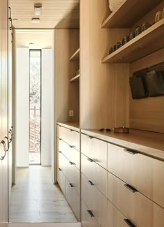 a long narrow kitchen with wooden cabinets and drawers