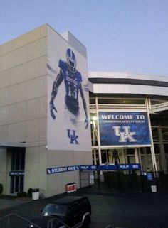 a car parked in front of a building with a large sign on it's side