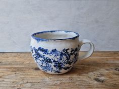 a blue and white cup sitting on top of a wooden table