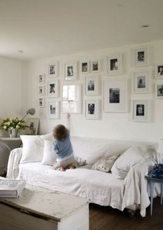 a small child sitting on top of a white couch