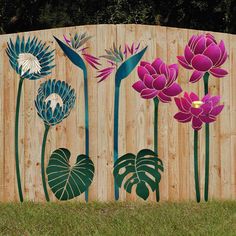 a wooden fence with flowers painted on the top and bottom, in front of it