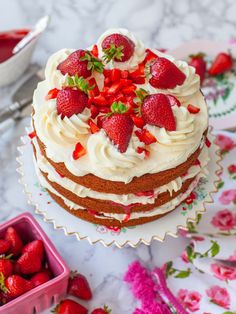 an easy strawberry shortcake cake with white frosting and fresh strawberries on top