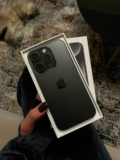 a person holding an iphone 11 pro in their left hand, with the box open