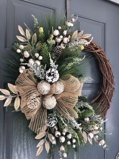 a wreath on the front door with pine cones and berries