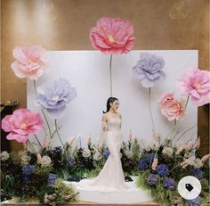 a woman standing in front of flowers on display