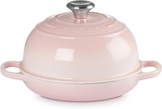 a pink ceramic casserole dish with two handles and a domed cover on the top