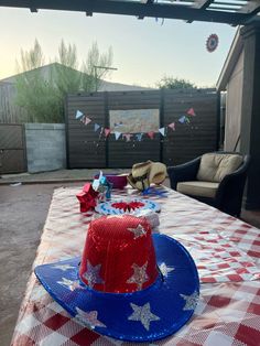 a red, white and blue hat sitting on top of a table covered in stars