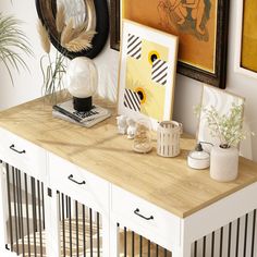 a wooden table topped with lots of pictures and plants next to a wall mounted art