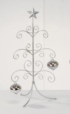 a metal christmas tree with ornaments hanging from it's sides and an ornament in the shape of a star