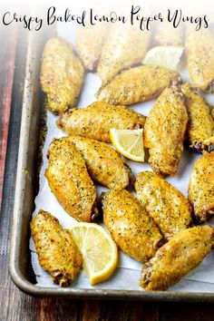 chicken wings with lemon slices on a baking sheet