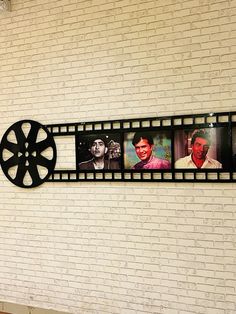 a movie reel hanging on the side of a brick wall