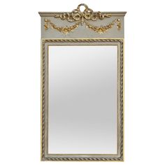 an ornate gold framed mirror on a white wall