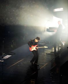 a man playing an electric guitar on stage