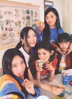 a group of young women sitting at a table eating food and posing for the camera