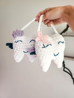 two crocheted tooth ornaments hanging from a hook