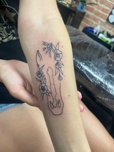 a woman's arm with a tattoo of a horse head and flowers on it