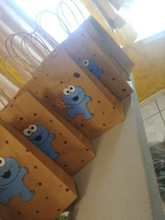 three brown bags with blue cartoon characters on them