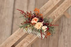 a comb decorated with flowers and foliage on top of a wooden chair next to a wall