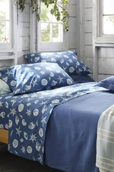 a bed covered in blue sheets and pillows